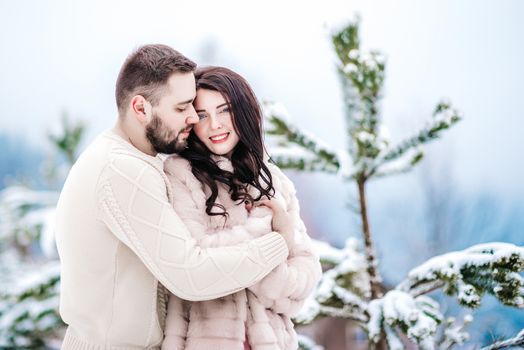 a bride in a fur coat with a fiance among the Carpathian mountains