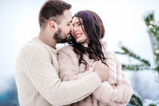 a bride in a fur coat with a fiance among the Carpathian mountains