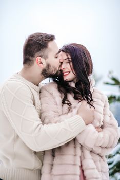 a bride in a fur coat with a fiance among the Carpathian mountains