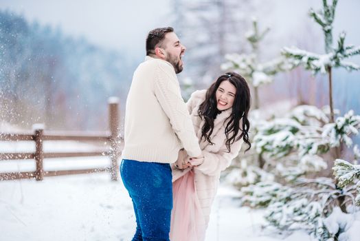 a bride in a fur coat with a fiance among the Carpathian mountains