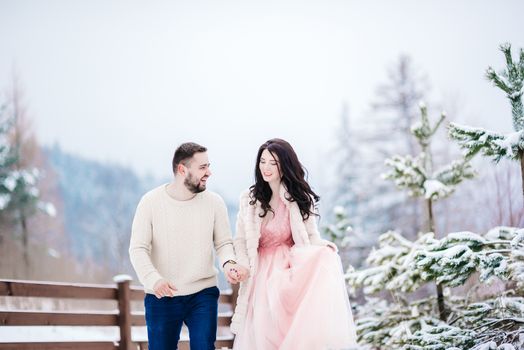 a bride in a fur coat with a fiance among the Carpathian mountains