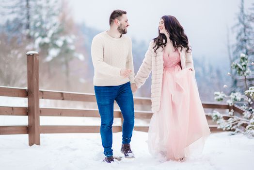 a bride in a fur coat with a fiance among the Carpathian mountains