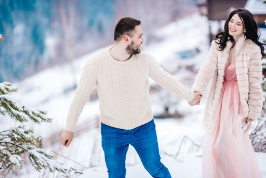 a bride in a fur coat with a fiance among the Carpathian mountains