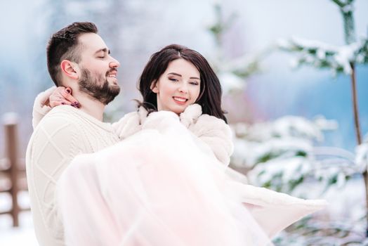 a bride in a fur coat with a fiance among the Carpathian mountains