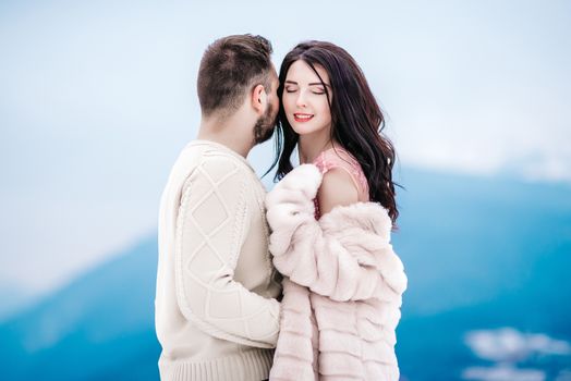 a bride in a fur coat with a fiance among the Carpathian mountains