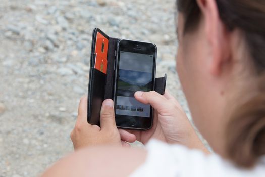 Woman with a smartphone - Looking at some self made photos