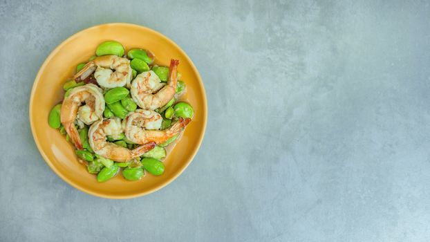 top view of Stir-Fried Twisted Cluster Bean with Shrimps/Butter Bean on orange dish