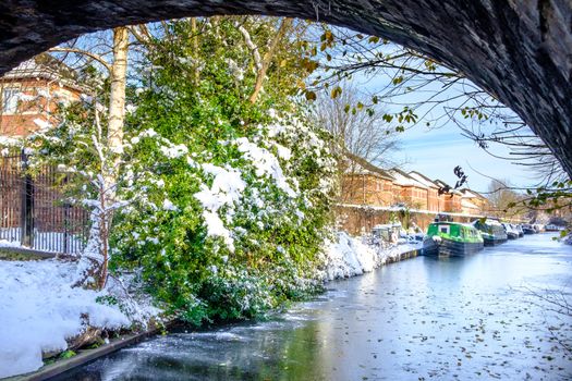 Snow covered canal boats seen in frozen Birmingham canal.