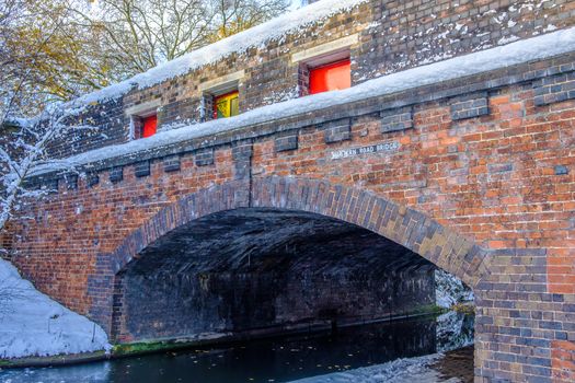 View of frozen Birmingham Canal and a bridge made of bricks