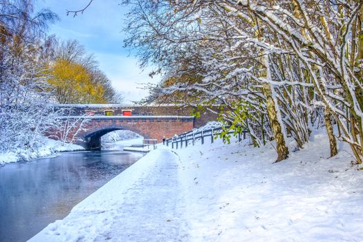 View of frozen Birmingham Canal and a bridge made of bricks