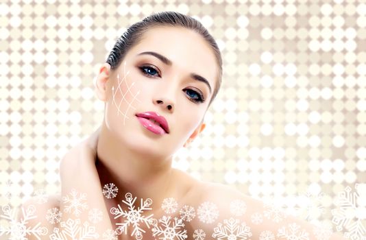 Young beautiful woman with clean fresh skin, abstract background with snowflakes