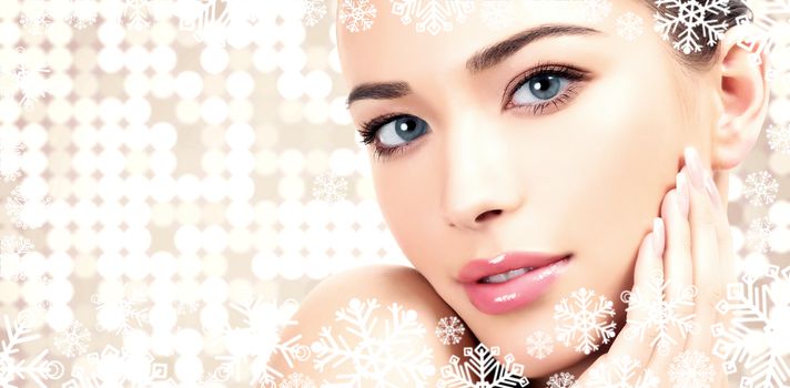 Pretty woman against an abstract background with circles and snowflakes. Winter skin treatment concept