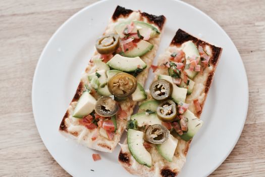 Delicious and fresh grilled sandwiches on a white plate. Wooden board.