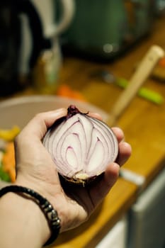 Fresh and tasty red onion in hand. Kitchen food concept.