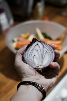 Fresh and tasty red onion in hand. Kitchen food concept.