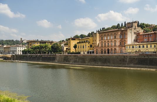 Scenic view of the Lungarno at historic center of Florence, Italy. Facades of old medieval houses on waterfront of the Arno River. Florence is a popular tourist destination of Europe.