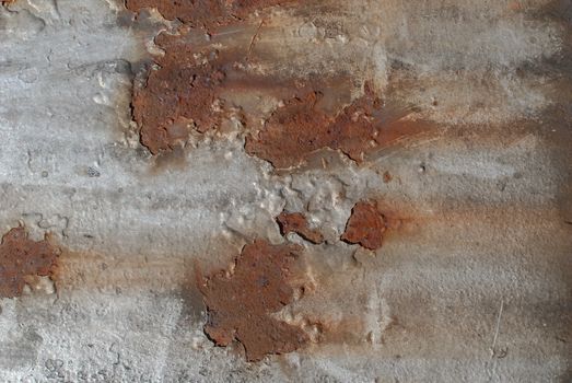 rusty iron surface covered with old chipped grey color paint, which has long been influenced by different climatic conditions