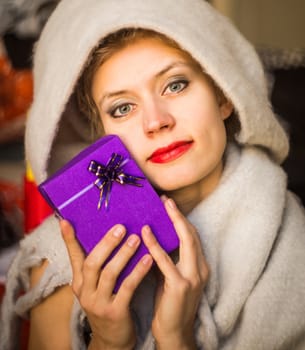 young caucasian womanis holding a gift in her hands. woman celebrating holiday with present