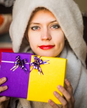 young caucasian woman is holding two gifts in her hands. woman celebrating holiday with presents