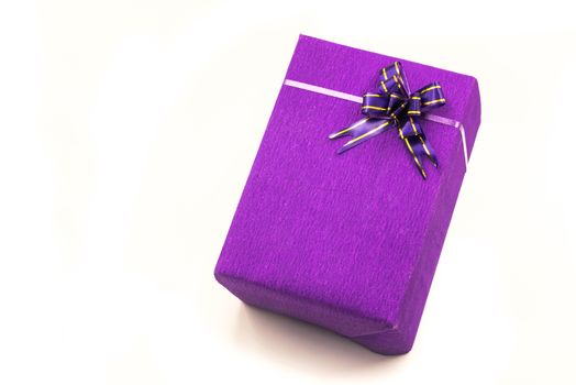 bright purple hand made gift box with nice crepe wrapping and purple bow. Happy holidays.