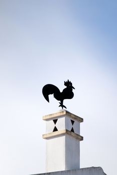 Typical black rooster on top of chimney.