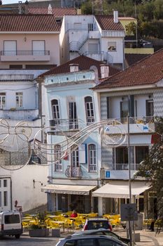 View of the typical architecture buildings from Monchique village with cafe with yellow chairs in Portugal.