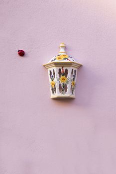 Street light ceramic cover and ladybird insect in the wall.