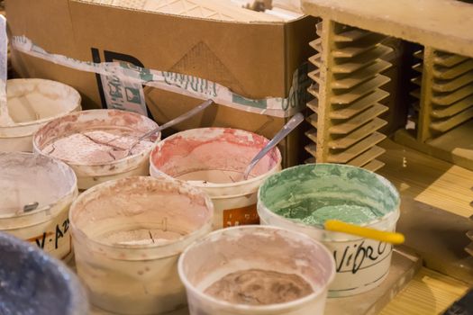 Artist table with used and dirty painting buckets.