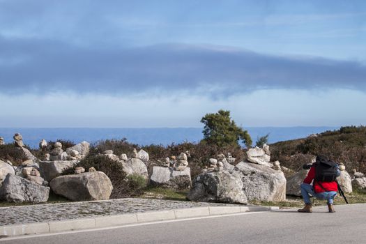 View of a photographer taking pictures of balanced stones.