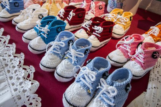 Varied mix of colorful knitted baby shoes.
