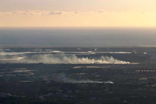 Horizon view coastline with smoke from fire covering a wide area.