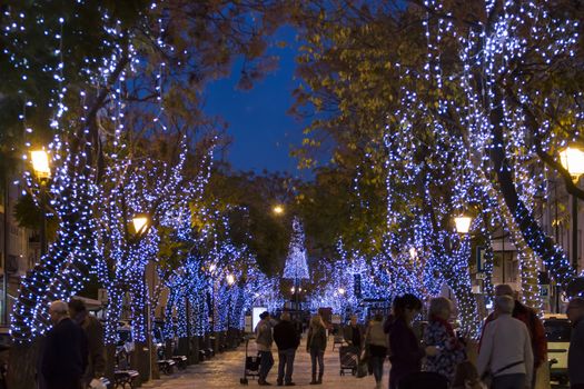 Beautiful view of christmas themed wrapped trees with decorative lights in Olhao city, Portugal.