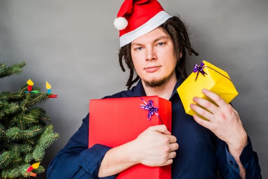 young caucasian man with afro hair holding christmas presents. christmas concept