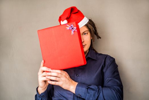 young european man in christmas hat with a gift