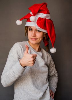 emotions. caucasian woman in santa hats smiling and showing thumbs up
