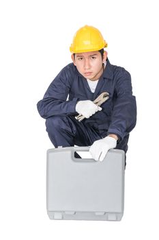 Young handyman sitting with his tool box isolated on white background