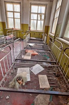 Room with beds in ruined kindergarten in Chernobyl