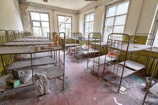 Room with beds in ruined kindergarten in Chernobyl