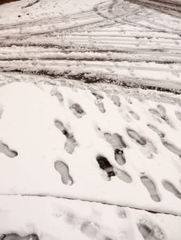 snow on path and road outside tire marks trails foot prints floor background; essex; england; uk