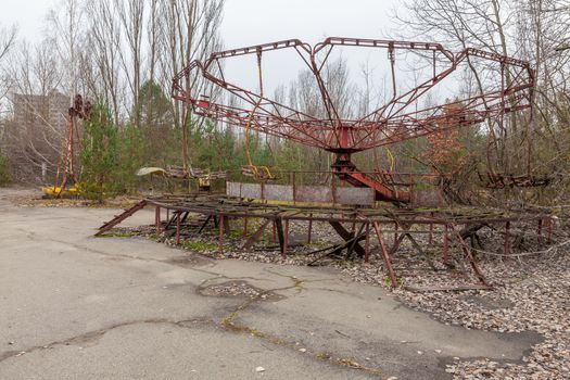 Attraction in amusement park in overgrown ghost city Pripyat near Chernobyl nuclear power plant in Ukraine.