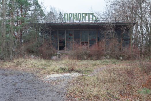 Abandoned and ruined building of river port in overgrown ghost city Pripyat near Chernobyl nuclear power plant in Ukraine.