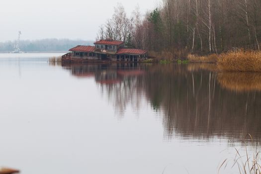 Sinking boat station building in overgrown ghost city Pripyat near Chernobyl nuclear power plant in Ukraine.