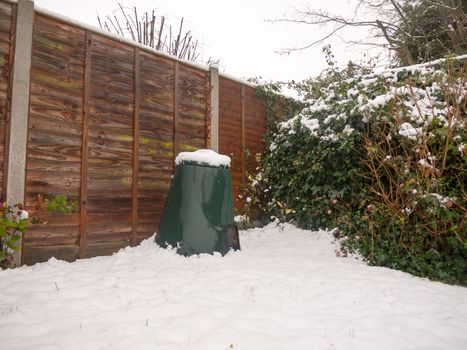 snow in back garden on green bin lid and fence and floor; essex; england; uk