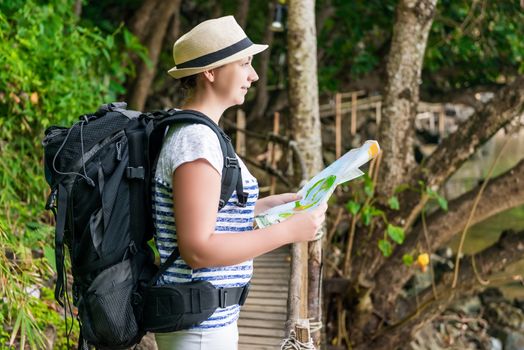 portrait of a woman with a map and a backpack on a trip to Asia