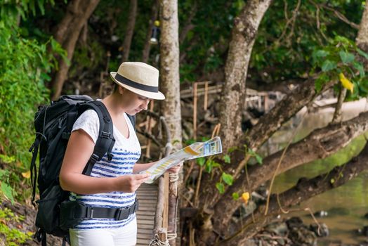 lost tourist with a map and a backpack is looking for a route