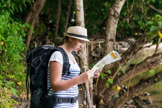 woman tourist in a hat with a backpack on a hike in Asia