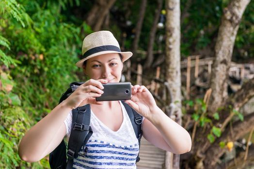 portrait of a tourist in a hat with a phone for a photo