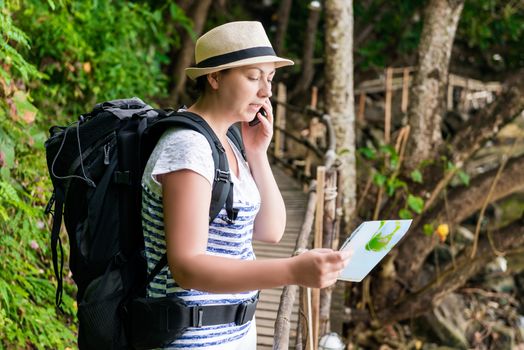 Lost tourist with a backpack and card calls for help by phone