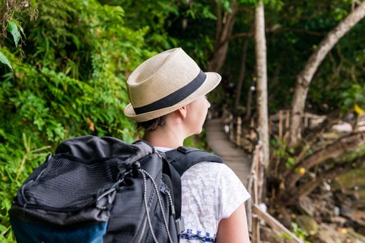 woman hiker in hike with a big backpack back view