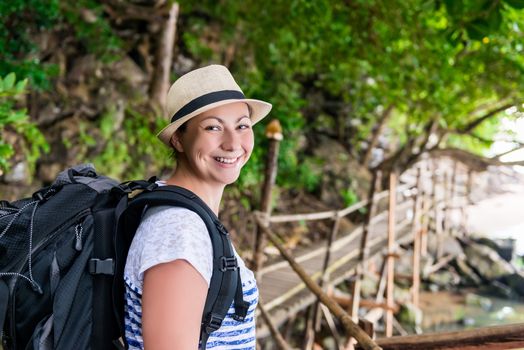 portrait of a smiling happy woman with a backpack hiking in the journey